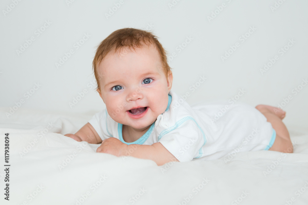 Funny little baby lying down on a blanket . Newborn child relaxing in bed. Nursery for young children. Textile and bedding for kids.


