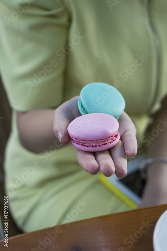 yellow pink and blue macarons on a plate and coffee