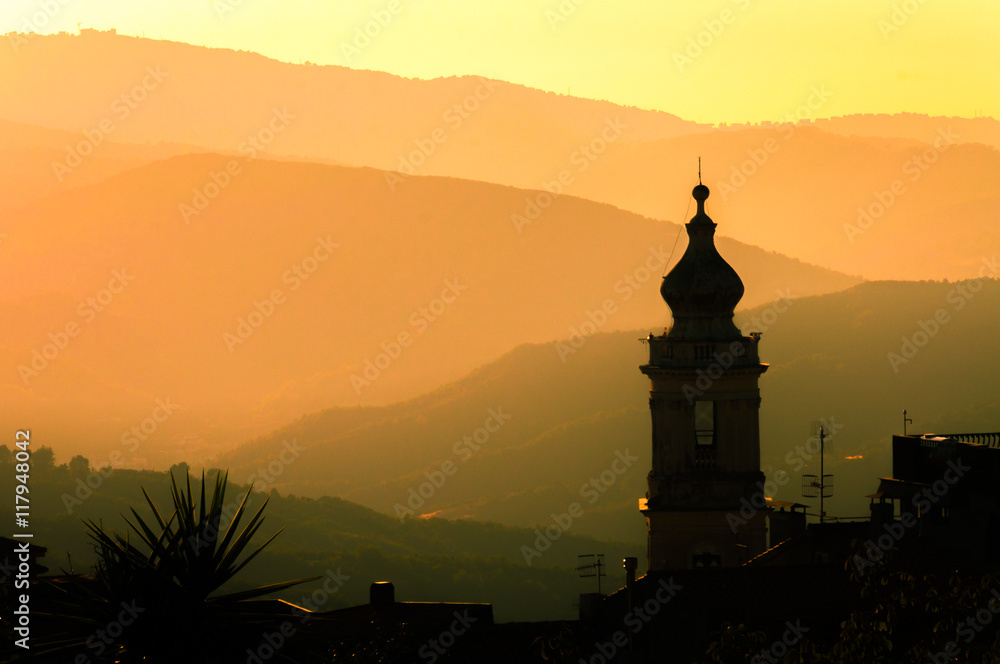 The setting sun cast a golden glow over the church steeple