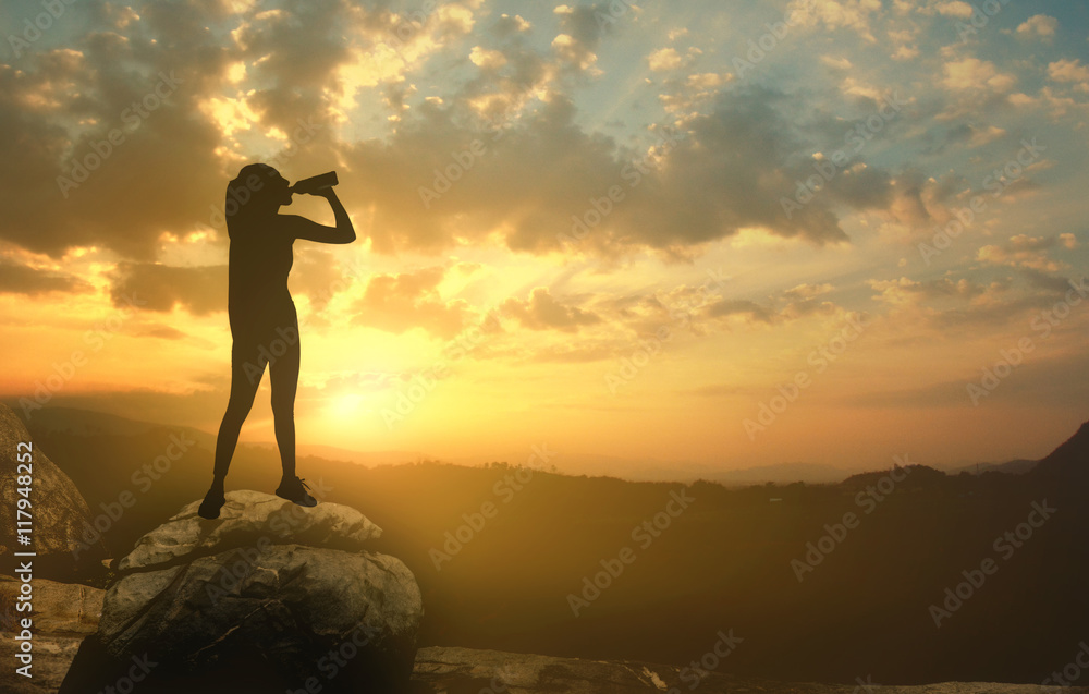 Silhouette of a girl at sunset with a bottle of water