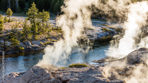 Steam from geysers on the rocky banks of the river. Upper Geyser Basin, Yellowstone National Park, Wyoming