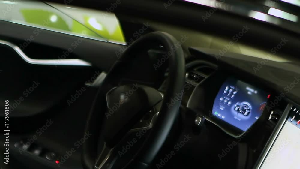 Man leaving car equipped with touch screens at filling station, after test drive Man leaving car equipped with touch screens at filling station, after test drive