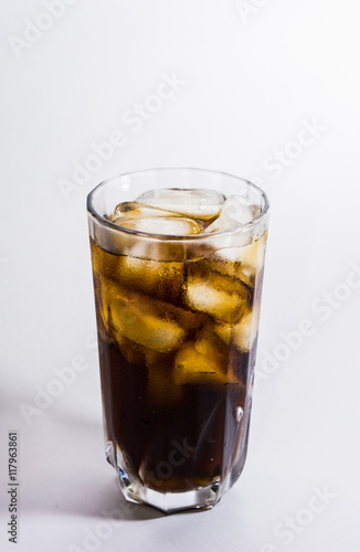 A glass of cold drink with ice on a white background