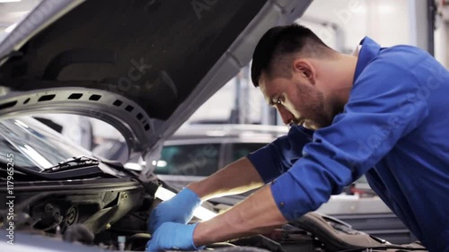 mechanic man with wrench repairing car at workshop 9