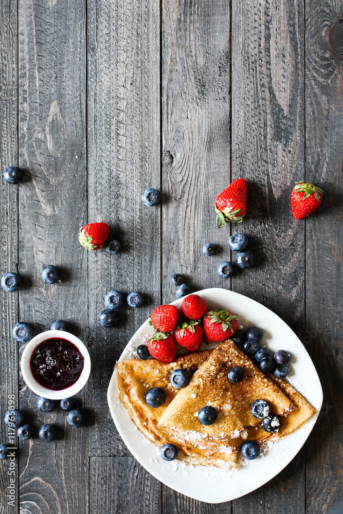 Delicious Crepes Breakfast with Dramatic light over a wood background Delicious Crepes Breakfast with Dramatic light over a wood background