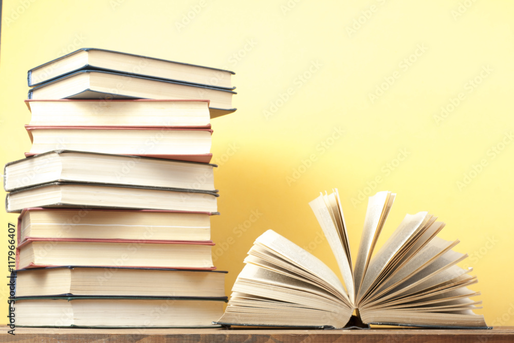 Naklejka premium Open book, hardback books on wooden table. Education background. Back to school. Copy space for text.