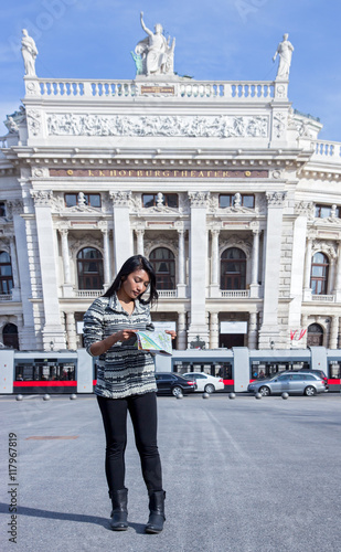 Photography Asian woman studying a map on the square near the theater