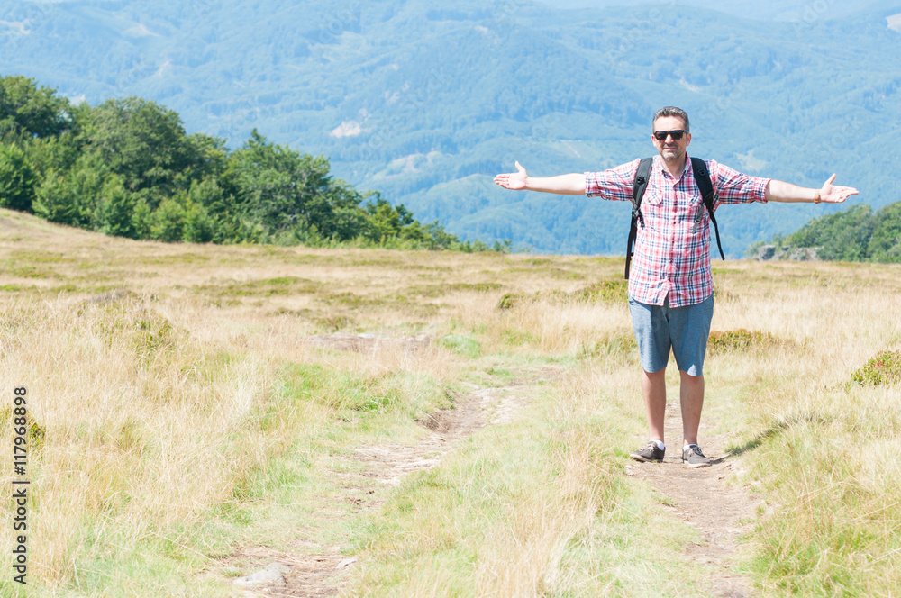 Man on footpath on mountain making freedom gesture Man on footpath on mountain making freedom gesture