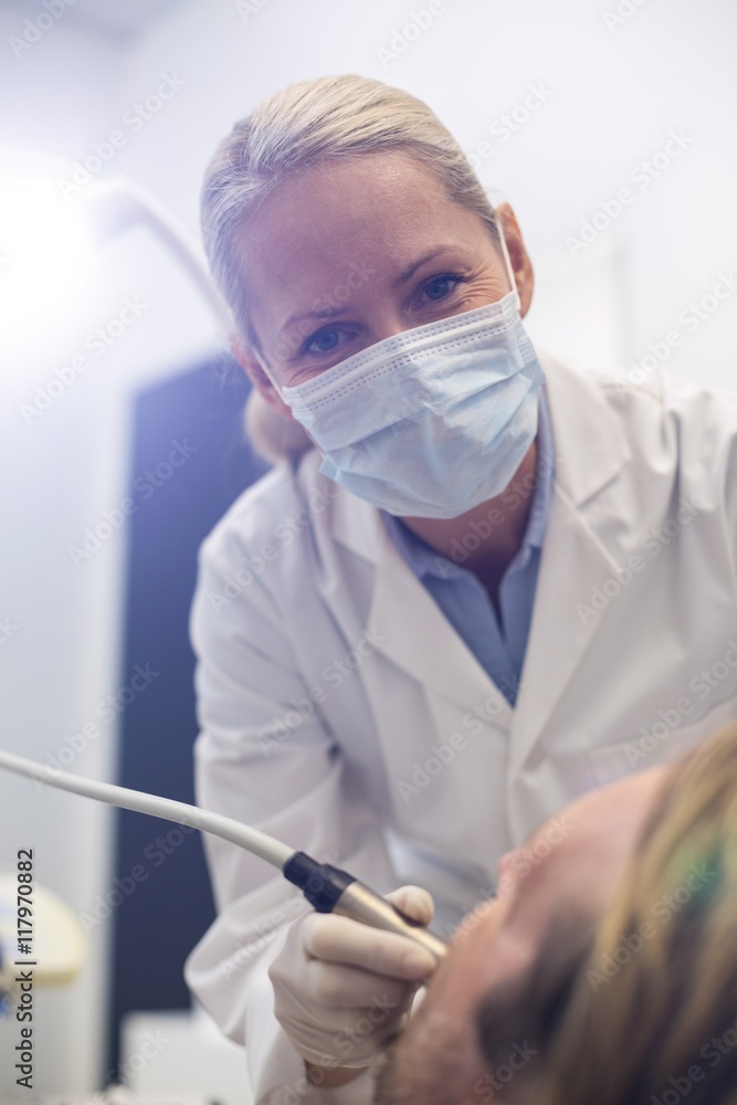 Naklejka premium Dentist examining a patient with tool