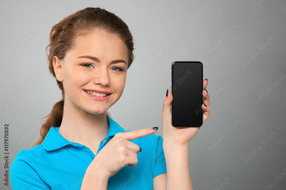 Smiling young woman showing blank smartphone screen Smiling young woman showing blank smartphone screen