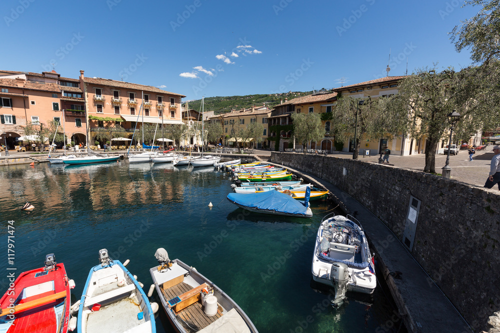 A row of fishing boats in the small harbor of Torri del Benaco. Garda Lake. Italy