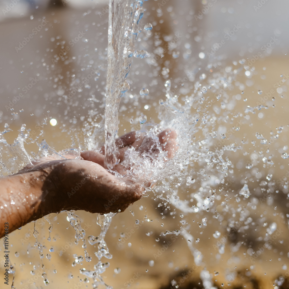 Close up of human hand catching water, ocean beach outdoors background Close up of human hand catching water, ocean beach outdoors background