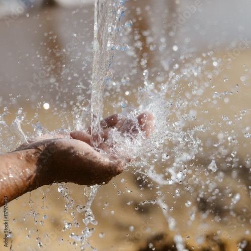 Close up of human hand catching water, ocean beach outdoors background