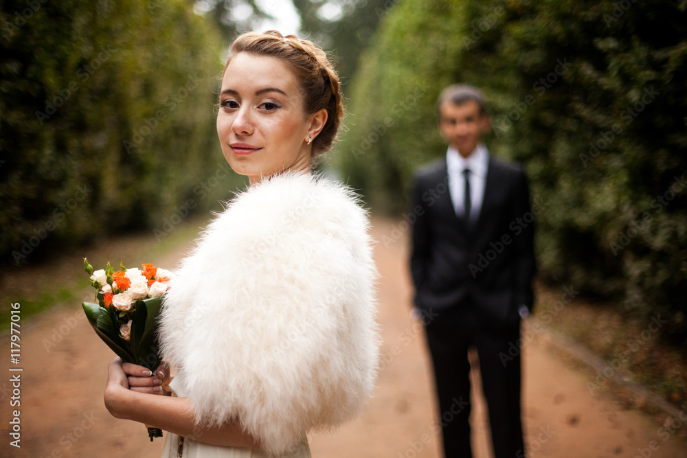 Bride with bright faces and shoulders covered with fur poses in Bride with bright faces and shoulders covered with fur poses in