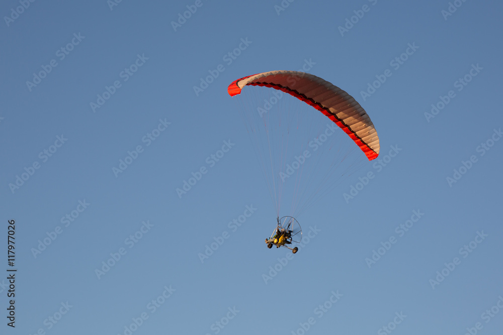 Motorised paraglider flying over mountains in summer day Motorised paraglider flying over mountains in summer day