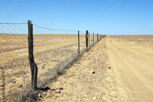 Fototapeta Naklejka Na Ścianę i Meble -  Dingo Dog Proof Fence in Desert Outback Australia