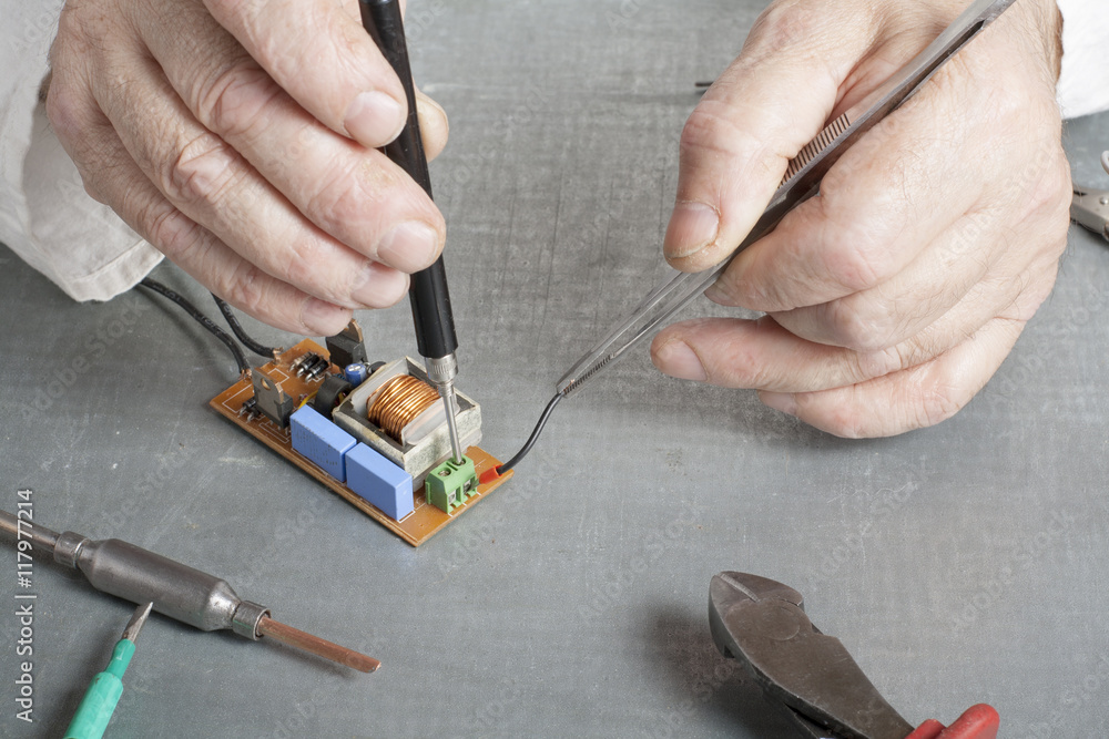 Hand of electrician with multimeter probe at electrical switchgear cabinet. Engineering tools Hand of electrician with multimeter probe at electrical switchgear cabinet. Engineering tools