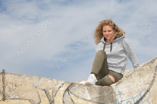 Young happy woman on a rocky natural wall.