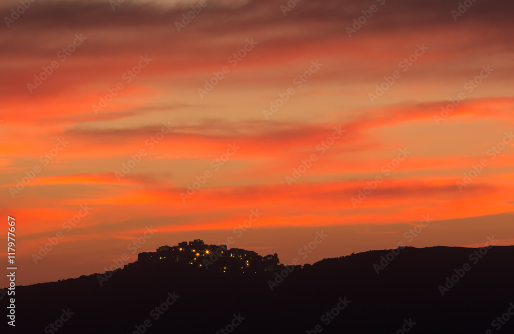 Village of Sant' Antonino in Corsica silhoutted against pink eve