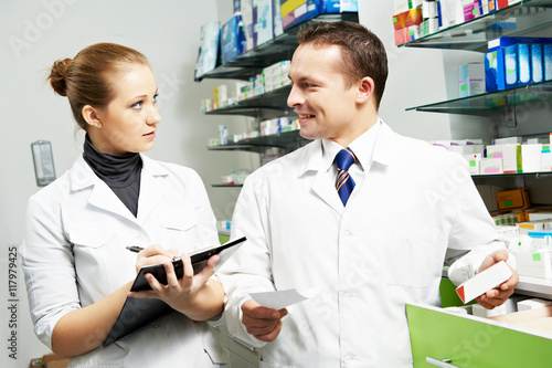 two pharmacy chemist workers in drugstore