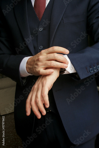 Closeup of man's hands holding a watch on the wirst
