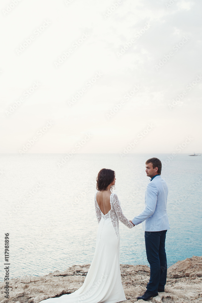 Man in blue suit admires a lady in dress with open gown standing