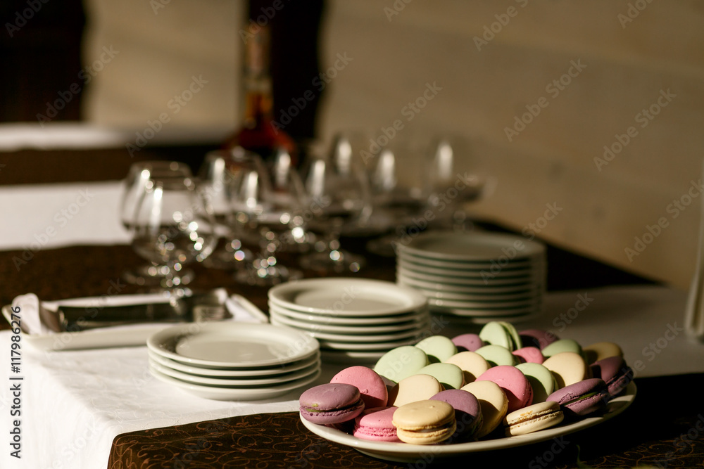 Pink, violet, green and yellow macaroons lie on the white plate