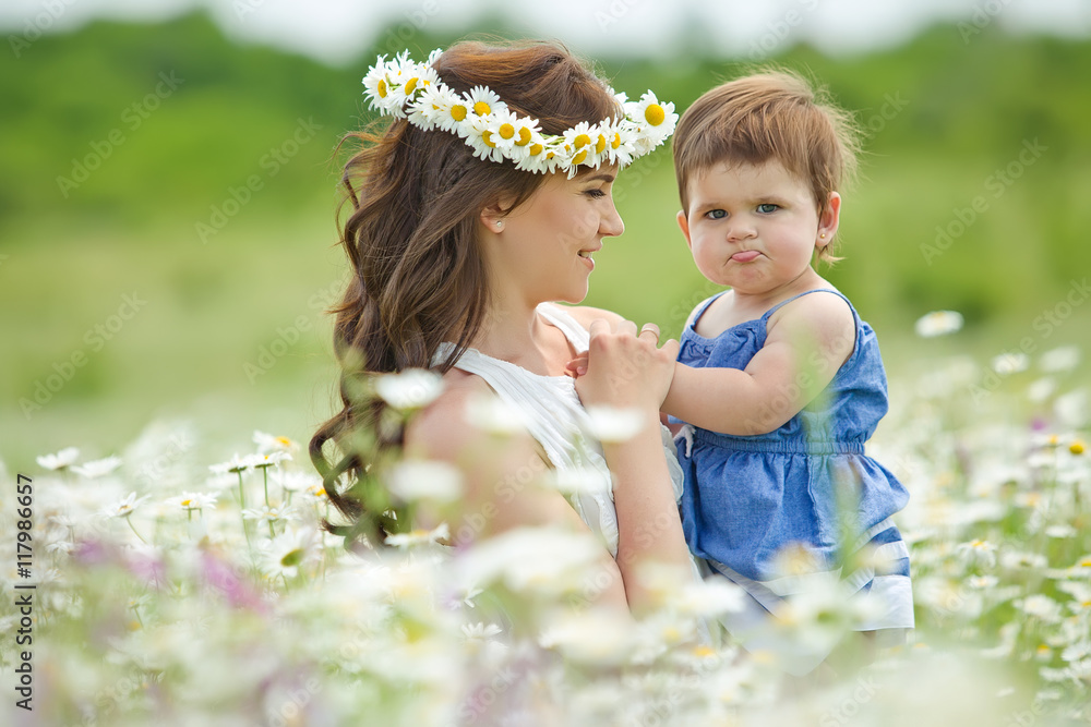 Happy mother with daughter in a camomile field Happy mother with daughter in a camomile field