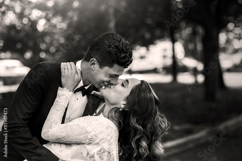 Black and white picture of handsome groom bending bride over and © IVASHstudio