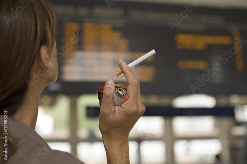 femme qui tient sa cigarette dans une gare