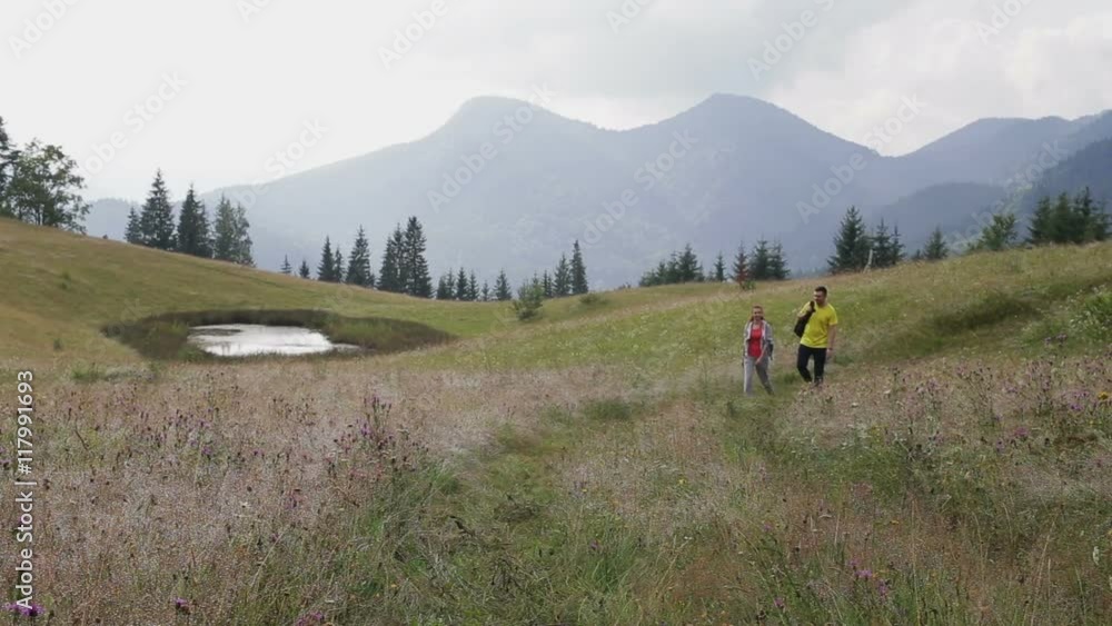 Couple Backpackers hiking on the path in mountains Couple Backpackers hiking on the path in mountains
