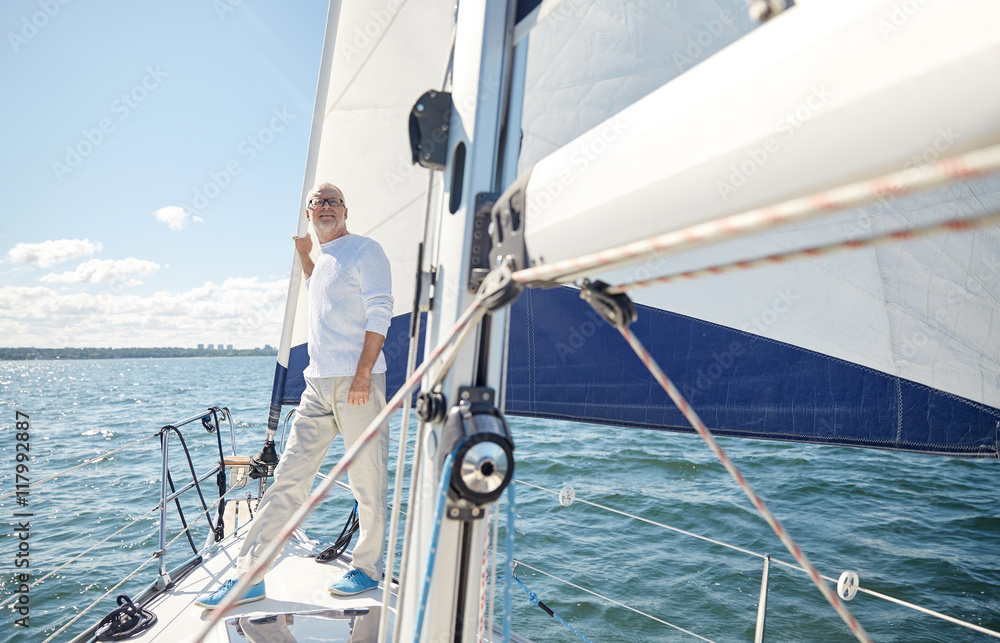 Fototapeta premium senior man on sail boat or yacht sailing in sea