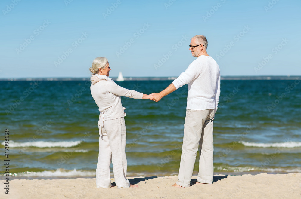 happy senior couple holding hands on summer beach happy senior couple holding hands on summer beach