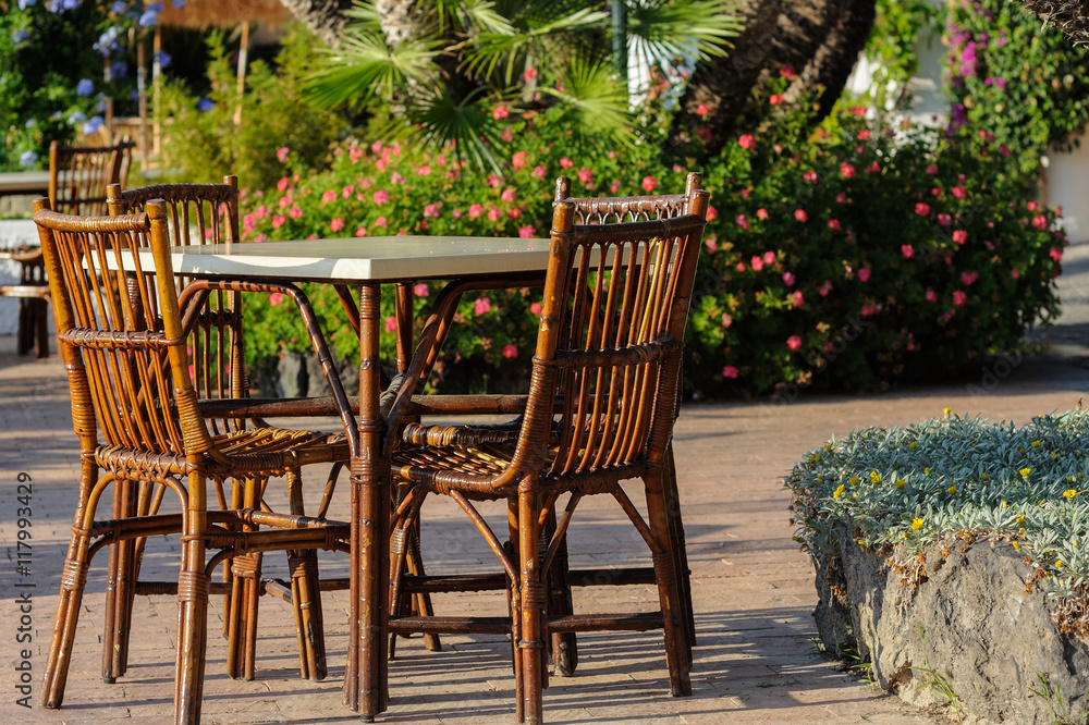 Tables and wicker chairs with straw sunshades in the restaurant