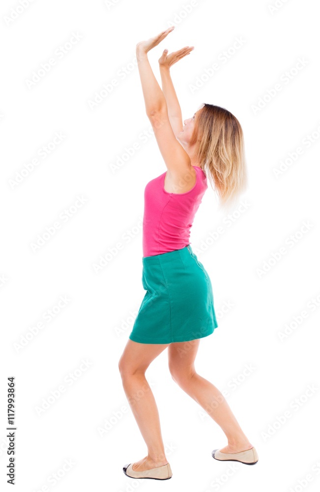 back view of woman protects hands from what is falling from above. woMan holding a heavy load Rear view people collection. backside view of person. Isolated over white background. Blond girl in a back view of woman protects hands from what is falling from above. woMan holding a heavy load Rear view people collection. backside view of person. Isolated over white background. Blond girl in a