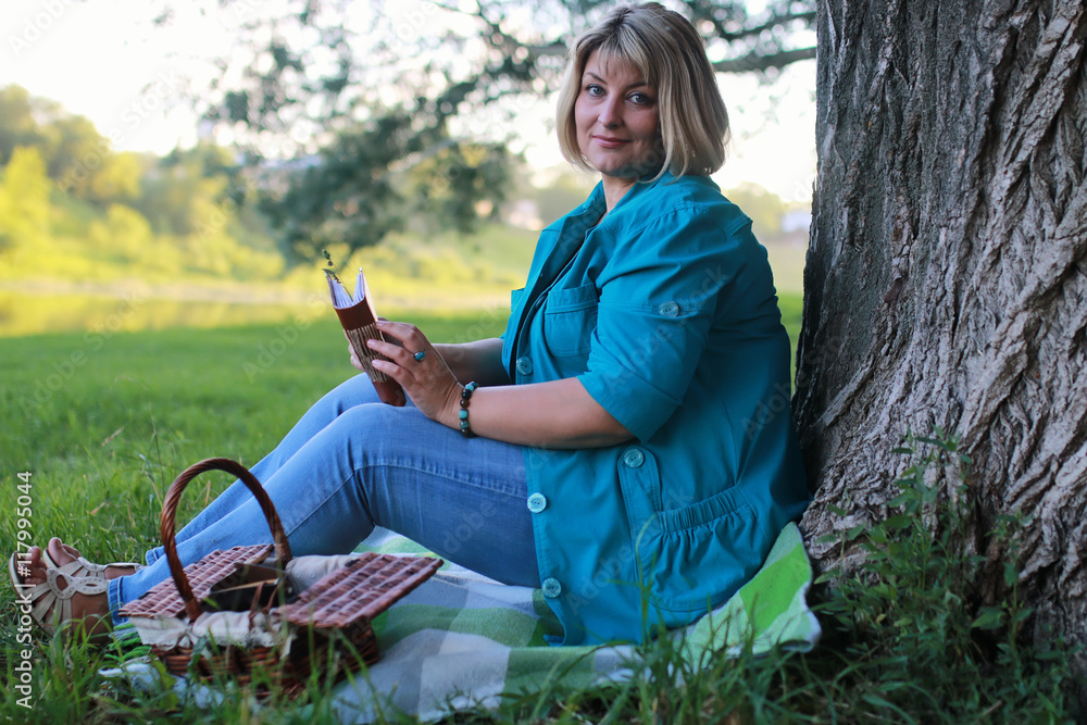 woman in park with book on the grass woman in park with book on the grass