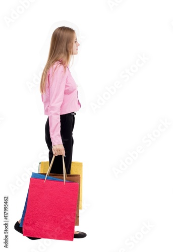 back view of going woman with shopping bags . beautiful girl in motion. backside view of person. Rear view people collection. Isolated over white background. The girl in the pink shirt is left