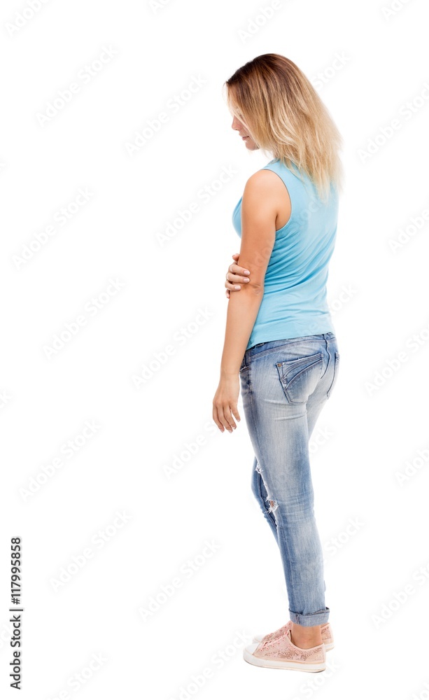 back view of standing young beautiful woman. girl watching. Rear view people collection. backside view of person. Isolated over white background. The girl in jeans and a blue t-shirt is back view of standing young beautiful woman. girl watching. Rear view people collection. backside view of person. Isolated over white background. The girl in jeans and a blue t-shirt is