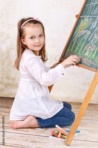 Little girl drawing on the blackboard