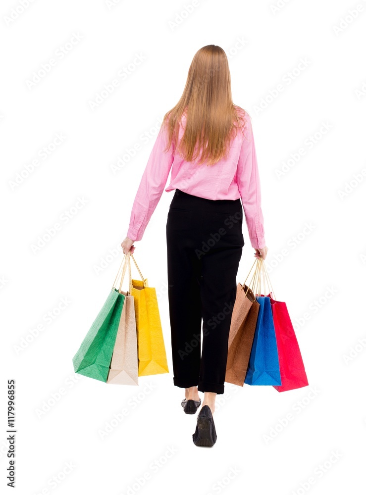 back view of going woman with shopping bags . beautiful girl in motion. backside view of person. Rear view people collection. Isolated over white background. A woman in a pink shirt goes the back view of going woman with shopping bags . beautiful girl in motion. backside view of person. Rear view people collection. Isolated over white background. A woman in a pink shirt goes the