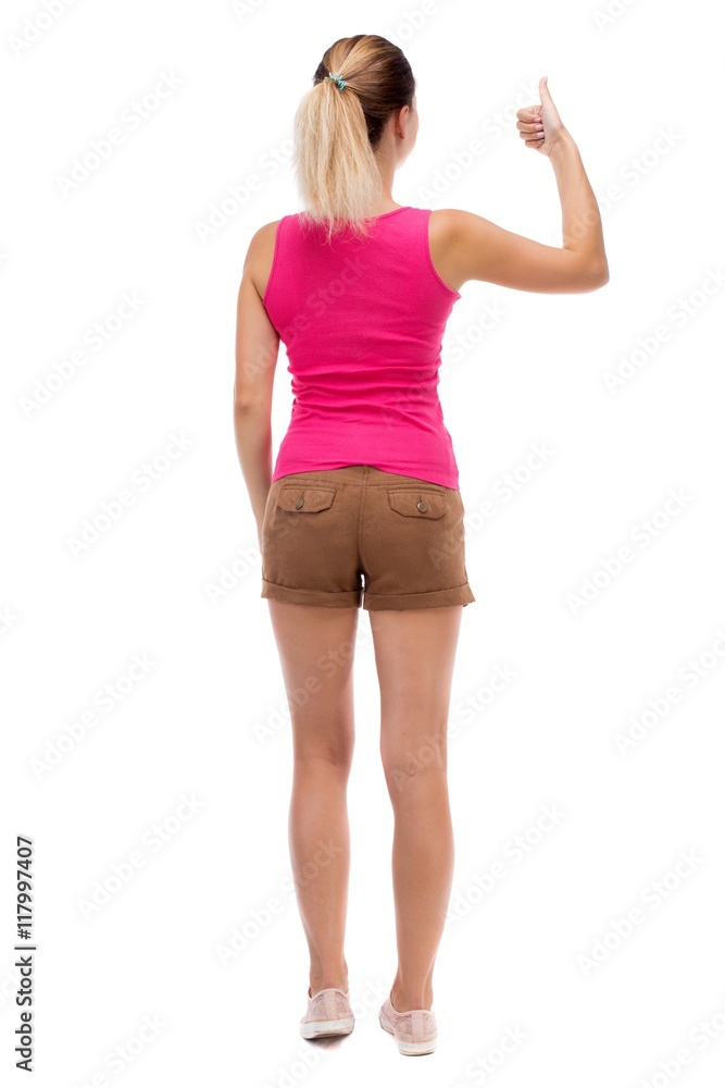 Back view of woman thumbs up. Rear view people collection. backside view of person. Isolated over white background. Blonde in brown shorts showing a thumbs up with his left hand. Back view of woman thumbs up. Rear view people collection. backside view of person. Isolated over white background. Blonde in brown shorts showing a thumbs up with his left hand.