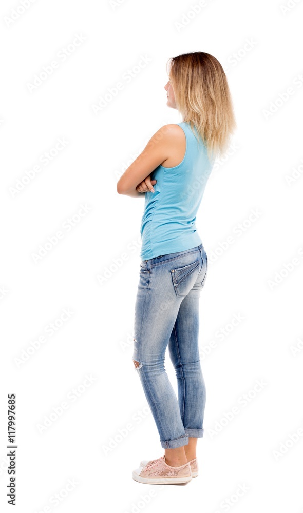 back view of standing young beautiful woman. girl watching. Rear view people collection. backside view of person. Isolated over white background. The girl in jeans and a blue t-shirt standing back view of standing young beautiful woman. girl watching. Rear view people collection. backside view of person. Isolated over white background. The girl in jeans and a blue t-shirt standing