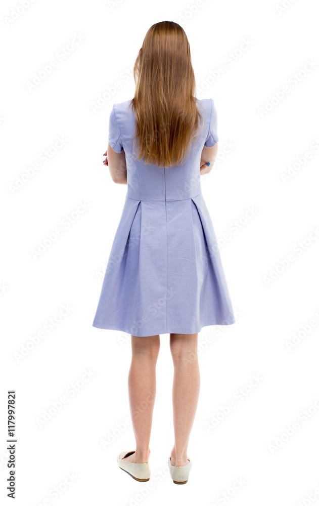 back view of standing young beautiful woman. girl watching. Rear view people collection. backside view of person. Isolated over white background. The girl in the blue dress standing with her back view of standing young beautiful woman. girl watching. Rear view people collection. backside view of person. Isolated over white background. The girl in the blue dress standing with her