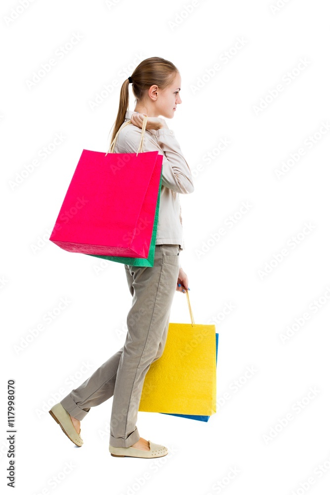 back view of going woman with shopping bags . beautiful girl in motion. backside view of person. Rear view people collection. Isolated over white background. Girl in gray jeans is right and back view of going woman with shopping bags . beautiful girl in motion. backside view of person. Rear view people collection. Isolated over white background. Girl in gray jeans is right and