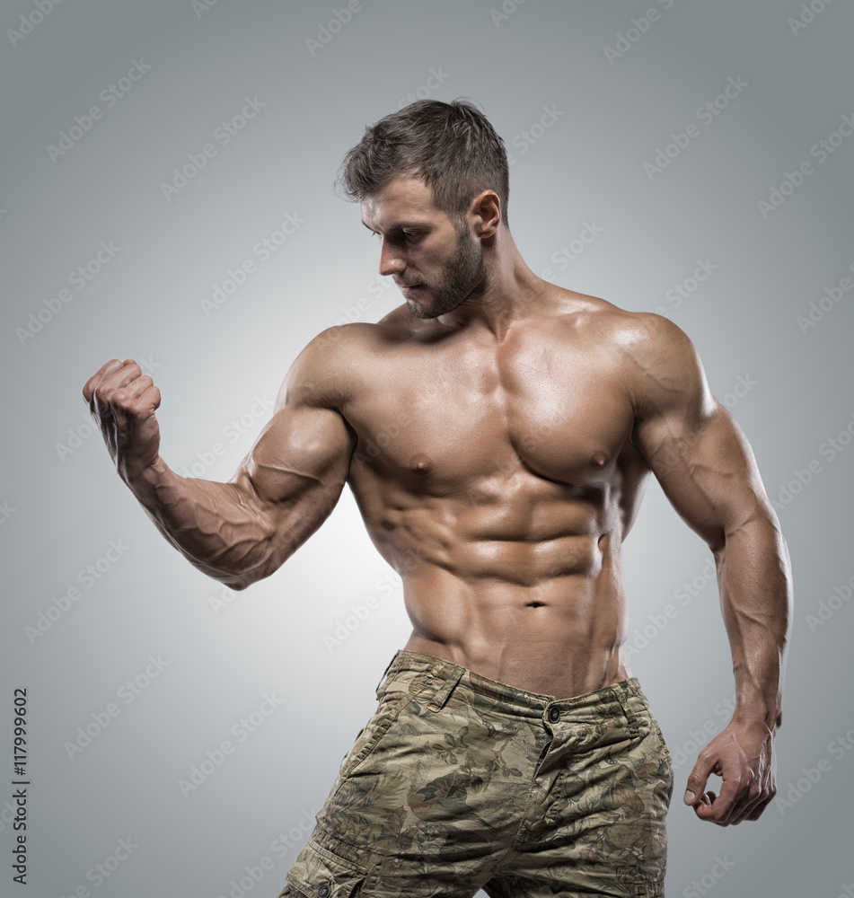 Muscular athlete bodybuilder man on a gray background