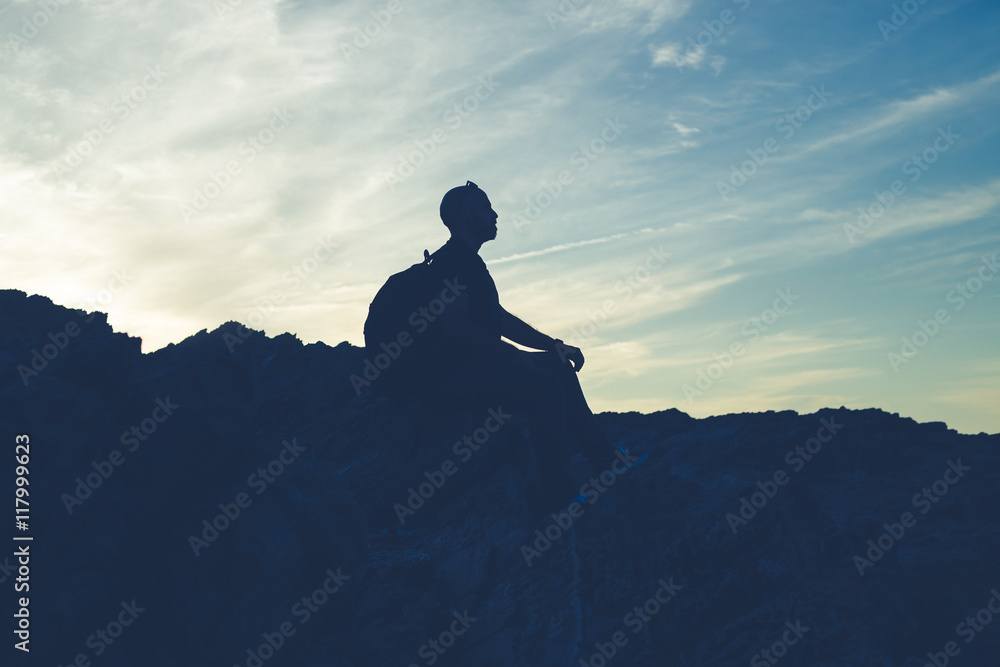 Back light silhouette of a man standing on a hill, overlooking,