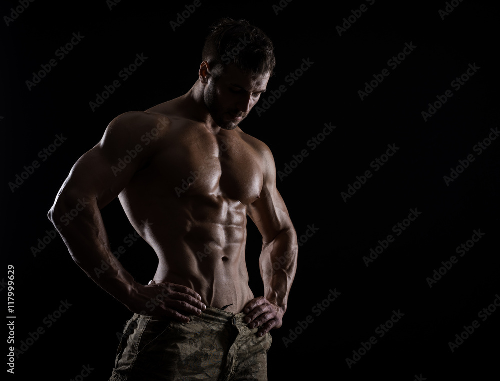 Fototapeta premium Muscular athlete bodybuilder man on a dark background