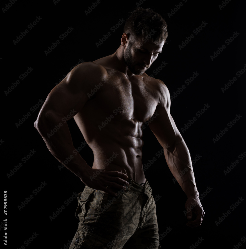 Muscular athlete bodybuilder man on a dark background