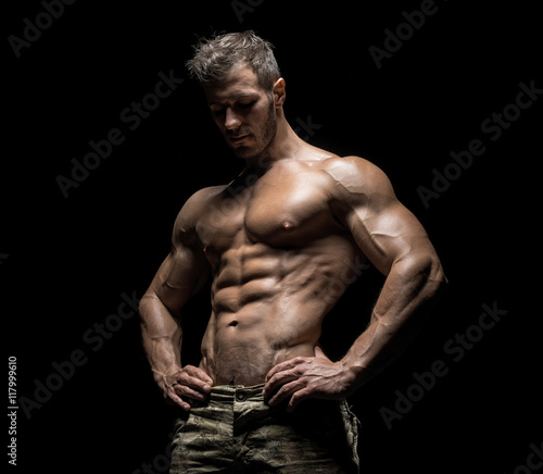 Muscular athlete bodybuilder man on a dark background