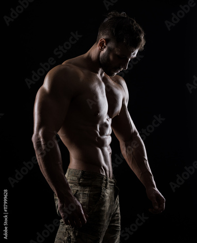 Muscular athlete bodybuilder man on a dark background